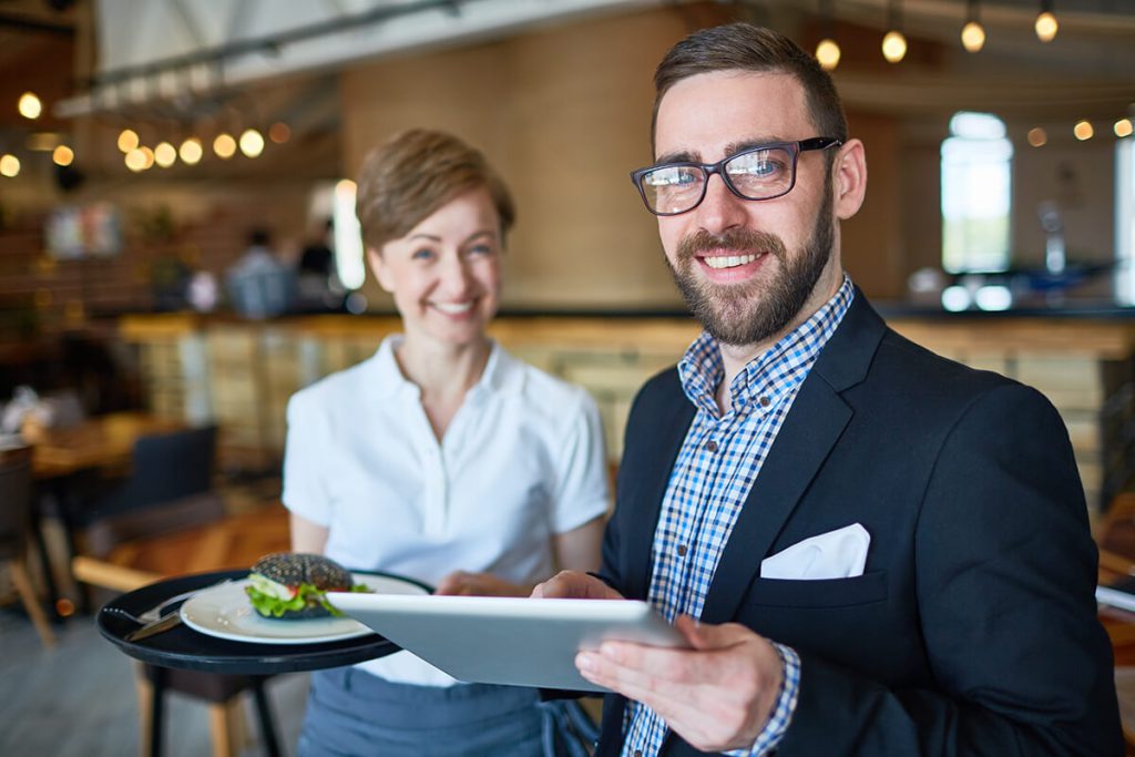 Métier de directeur de restaurant. Le directeur est avec une de ses serveuse